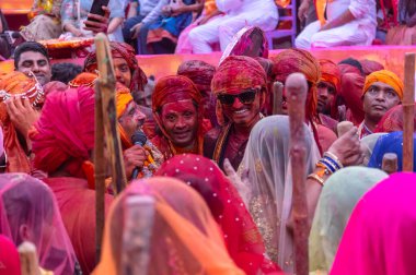 Barsana, Uttar Pradesh, Hindistan - 18 Mart 2024: Geleneksel giysiler ve rengarenk yüzlü Hindu erkek grubu, Barsana 'nın Rangili Gali' sindeki lathmar Holi 'yi geleneksel olarak kutluyorlar..
