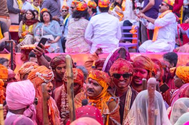 Barsana, Uttar Pradesh, Hindistan - 18 Mart 2024: Geleneksel giysiler ve rengarenk yüzlü Hindu erkek grubu, Barsana 'nın Rangili Gali' sindeki lathmar Holi 'yi geleneksel olarak kutluyorlar..