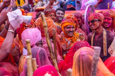 Barsana, Uttar Pradesh, Hindistan - 18 Mart 2024: Geleneksel giysiler ve rengarenk yüzlü Hindu erkek grubu, Barsana 'nın Rangili Gali' sindeki lathmar Holi 'yi geleneksel olarak kutluyorlar..