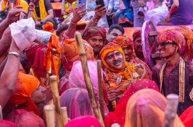 Barsana, Uttar Pradesh, Hindistan - 18 Mart 2024: Geleneksel giysiler ve rengarenk yüzlü Hindu erkek grubu, Barsana 'nın Rangili Gali' sindeki lathmar Holi 'yi geleneksel olarak kutluyorlar..