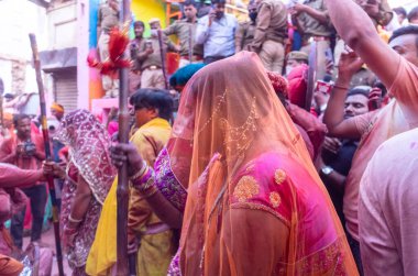 Barsana, Uttar Pradesh, Hindistan - 18 Mart 2024: Geleneksel giysiler ve rengarenk yüzlü Hindu erkek grubu, Barsana 'nın Rangili Gali' sindeki lathmar Holi 'yi geleneksel olarak kutluyorlar..