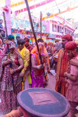Barsana, Uttar Pradesh, Hindistan - 18 Mart 2024: Geleneksel giysiler ve rengarenk yüzlü Hindu erkek grubu, Barsana 'nın Rangili Gali' sindeki lathmar Holi 'yi geleneksel olarak kutluyorlar..