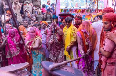 Barsana, Uttar Pradesh, Hindistan - 18 Mart 2024: Geleneksel giysiler ve rengarenk yüzlü Hindu erkek grubu, Barsana 'nın Rangili Gali' sindeki lathmar Holi 'yi geleneksel olarak kutluyorlar..