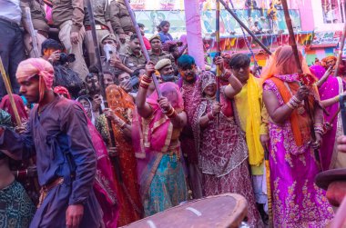 Barsana, Uttar Pradesh, Hindistan - 18 Mart 2024: Geleneksel giysiler ve rengarenk yüzlü Hindu erkek grubu, Barsana 'nın Rangili Gali' sindeki lathmar Holi 'yi geleneksel olarak kutluyorlar..
