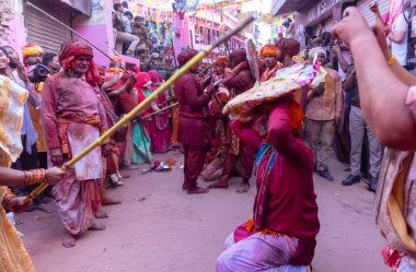 Barsana, Uttar Pradesh, Hindistan - 18 Mart 2024: Geleneksel giysiler ve rengarenk yüzlü Hindu erkek grubu, Barsana 'nın Rangili Gali' sindeki lathmar Holi 'yi geleneksel olarak kutluyorlar..