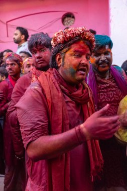 Barsana, Uttar Pradesh, Hindistan - 18 Mart 2024: Geleneksel giysiler ve rengarenk yüzlü Hindu erkek grubu, Barsana 'nın Rangili Gali' sindeki lathmar Holi 'yi geleneksel olarak kutluyorlar..