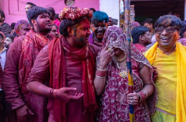 Barsana, Uttar Pradesh, Hindistan - 18 Mart 2024: Geleneksel giysiler ve rengarenk yüzlü Hindu erkek grubu, Barsana 'nın Rangili Gali' sindeki lathmar Holi 'yi geleneksel olarak kutluyorlar..