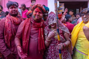 Barsana, Uttar Pradesh, Hindistan - 18 Mart 2024: Geleneksel giysiler ve rengarenk yüzlü Hindu erkek grubu, Barsana 'nın Rangili Gali' sindeki lathmar Holi 'yi geleneksel olarak kutluyorlar..