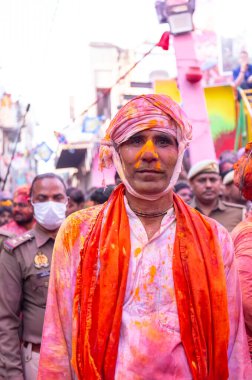 Barsana, Uttar Pradesh, Hindistan - 18 Mart 2024: Geleneksel giysiler ve rengarenk yüzlü Hindu erkek grubu, Barsana 'nın Rangili Gali' sindeki lathmar Holi 'yi geleneksel olarak kutluyorlar..