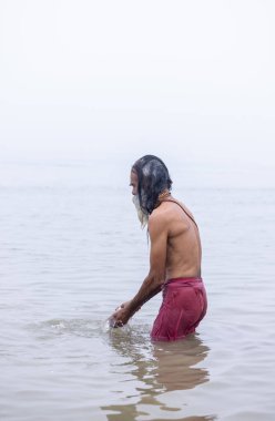 Prayagraj, Uttar Pradesh, Hindistan - 13 Ocak 2025: Mahakumbh, Mahakumbh, Kutsal Nehir Ganga 'sında duran kutsal erkek sadhu baba portresi.