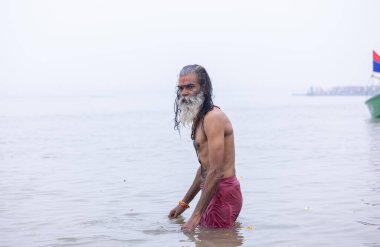 Prayagraj, Uttar Pradesh, Hindistan - 13 Ocak 2025: Mahakumbh, Mahakumbh, Kutsal Nehir Ganga 'sında duran kutsal erkek sadhu baba portresi.