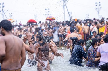 Prayagraj, Uttar Pradesh, India - January 2025: Mahakumbh, Group of holy male sadhu baba taking holy dip at sangam in river ganga during the makar sankranti amrit snaan at mahakumbh in prayagraj. clipart