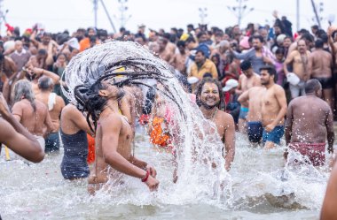 Prayagraj, Uttar Pradesh, Hindistan - Ocak 2025: Mahakumbh, Mahakumbh, kutsal erkek sadhu baba grubu makar sankranti amrit snaan sırasında Ganga nehrinde kutsal dalış yapıyor.
