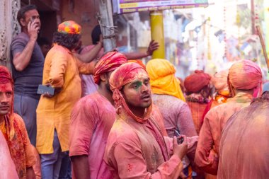 Barsana, Uttar Pradesh, Hindistan - 18 Mart 2024: Nandgaon 'dan Hindu erkek portresi Kafasını deri bir kalkanla koruyor Barsana' lı bir kadın tarafından bir lathmar holi geleneği olarak vurulan bambu çubuğu