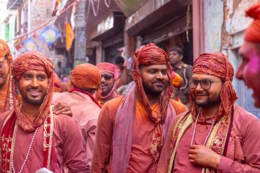 Barsana, Uttar Pradesh, India - March 18 2024: Portrait of hindu male from nandgaon protecting head with leather shield from a bamboo stick hitting by a women of barsana as a tradition of lathmar holi clipart