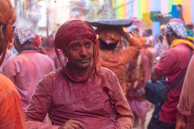 Barsana, Uttar Pradesh, Hindistan - 18 Mart 2024: Nandgaon 'dan Hindu erkek portresi Kafasını deri bir kalkanla koruyor Barsana' lı bir kadın tarafından bir lathmar holi geleneği olarak vurulan bambu çubuğu