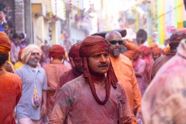 Barsana, Uttar Pradesh, Hindistan - 18 Mart 2024: Nandgaon 'dan Hindu erkek portresi Kafasını deri bir kalkanla koruyor Barsana' lı bir kadın tarafından bir lathmar holi geleneği olarak vurulan bambu çubuğu