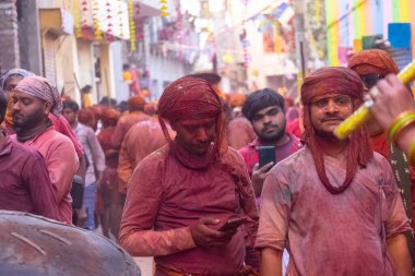 Barsana, Uttar Pradesh, Hindistan - 18 Mart 2024: Nandgaon 'dan Hindu erkek portresi Kafasını deri bir kalkanla koruyor Barsana' lı bir kadın tarafından bir lathmar holi geleneği olarak vurulan bambu çubuğu