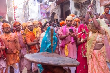 Barsana, Uttar Pradesh, Hindistan - 18 Mart 2024: Nandgaon 'dan Hindu erkek portresi Kafasını deri bir kalkanla koruyor Barsana' lı bir kadın tarafından bir lathmar holi geleneği olarak vurulan bambu çubuğu