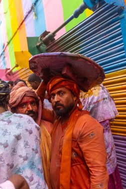 Barsana, Uttar Pradesh, Hindistan - 18 Mart 2024: Nandgaon 'dan Hindu erkek portresi Kafasını deri bir kalkanla koruyor Barsana' lı bir kadın tarafından bir lathmar holi geleneği olarak vurulan bambu çubuğu