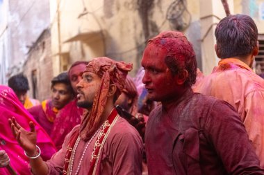 Barsana, Uttar Pradesh, Hindistan - 18 Mart 2024: Nandgaon 'dan Hindu erkek portresi Kafasını deri bir kalkanla koruyor Barsana' lı bir kadın tarafından bir lathmar holi geleneği olarak vurulan bambu çubuğu