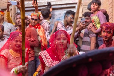 Barsana, Uttar Pradesh, Hindistan - 18 Mart 2024: Nandgaon 'dan Hindu erkek portresi Kafasını deri bir kalkanla koruyor Barsana' lı bir kadın tarafından bir lathmar holi geleneği olarak vurulan bambu çubuğu