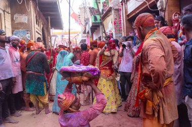 Barsana, Uttar Pradesh, Hindistan - 18 Mart 2024: Nandgaon 'dan Hindu erkek portresi Kafasını deri bir kalkanla koruyor Barsana' lı bir kadın tarafından bir lathmar holi geleneği olarak vurulan bambu çubuğu