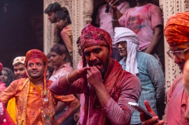 Barsana, Uttar Pradesh, Hindistan - 18 Mart 2024: Nandgaon 'dan Hindu erkek portresi Kafasını deri bir kalkanla koruyor Barsana' lı bir kadın tarafından bir lathmar holi geleneği olarak vurulan bambu çubuğu