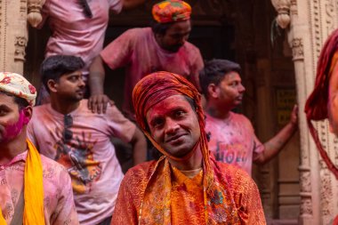 Barsana, Uttar Pradesh, India - March 18 2024: Portrait of hindu male from nandgaon protecting head with leather shield from a bamboo stick hitting by a women of barsana as a tradition of lathmar holi clipart