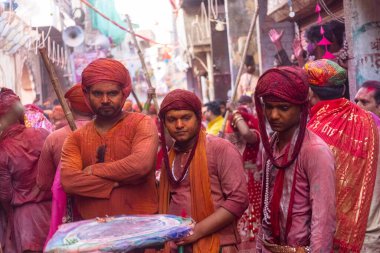 Barsana, Uttar Pradesh, Hindistan - 18 Mart 2024: Nandgaon 'dan Hindu erkek portresi Kafasını deri bir kalkanla koruyor Barsana' lı bir kadın tarafından bir lathmar holi geleneği olarak vurulan bambu çubuğu