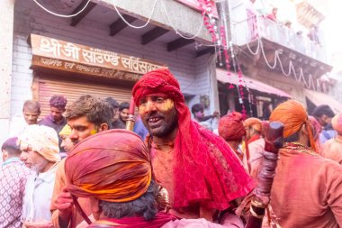Barsana, Uttar Pradesh, Hindistan - 18 Mart 2024: Nandgaon 'dan Hindu erkek portresi Kafasını deri bir kalkanla koruyor Barsana' lı bir kadın tarafından bir lathmar holi geleneği olarak vurulan bambu çubuğu