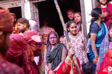 Barsana, Uttar Pradesh, Hindistan - 18 Mart 2024: Nandgaon 'dan Hindu erkek portresi Kafasını deri bir kalkanla koruyor Barsana' lı bir kadın tarafından bir lathmar holi geleneği olarak vurulan bambu çubuğu