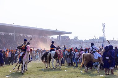 Anandpur Sahib, Punjab, Hindistan - 19 Mart 2022: Sih erkek (Nihang Sardar) Punjab 'daki holi sırasında ata binerken dövüş sanatı ve polo sergiledi.