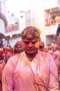 Barsana, Uttar Pradesh, Hindistan - 18 Mart 2024: Geleneksel giysiler ve rengarenk yüzlü Hindu erkek grubu, Barsana 'nın Rangili Gali' sindeki lathmar Holi 'yi geleneksel olarak kutluyorlar..