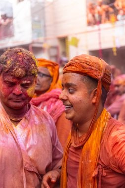 Barsana, Uttar Pradesh, Hindistan - 18 Mart 2024: Geleneksel giysiler ve rengarenk yüzlü Hindu erkek grubu, Barsana 'nın Rangili Gali' sindeki lathmar Holi 'yi geleneksel olarak kutluyorlar..