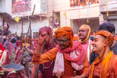 Barsana, Uttar Pradesh, Hindistan - 18 Mart 2024: Geleneksel giysiler ve rengarenk yüzlü Hindu erkek grubu, Barsana 'nın Rangili Gali' sindeki lathmar Holi 'yi geleneksel olarak kutluyorlar..