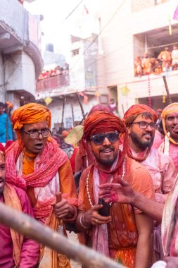 Barsana, Uttar Pradesh, Hindistan - 18 Mart 2024: Geleneksel giysiler ve rengarenk yüzlü Hindu erkek grubu, Barsana 'nın Rangili Gali' sindeki lathmar Holi 'yi geleneksel olarak kutluyorlar..