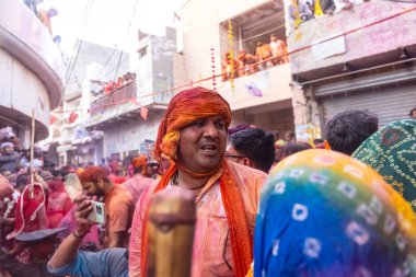 Barsana, Uttar Pradesh, Hindistan - 18 Mart 2024: Geleneksel giysiler ve rengarenk yüzlü Hindu erkek grubu, Barsana 'nın Rangili Gali' sindeki lathmar Holi 'yi geleneksel olarak kutluyorlar..