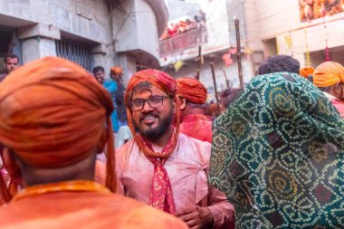 Barsana, Uttar Pradesh, Hindistan - 18 Mart 2024: Geleneksel giysiler ve rengarenk yüzlü Hindu erkek grubu, Barsana 'nın Rangili Gali' sindeki lathmar Holi 'yi geleneksel olarak kutluyorlar..