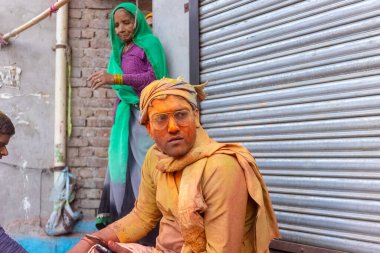 Barsana, Uttar Pradesh, Hindistan - 18 Mart 2024: Geleneksel giysiler ve rengarenk yüzlü Hindu erkek grubu, Barsana 'nın Rangili Gali' sindeki lathmar Holi 'yi geleneksel olarak kutluyorlar..
