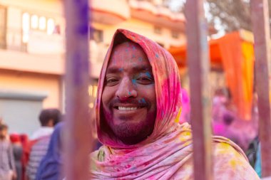 Barsana, Uttar Pradesh, Hindistan - 18 Mart 2024: Geleneksel giysiler ve rengarenk yüzlü Hindu erkek grubu, Barsana 'nın Rangili Gali' sindeki lathmar Holi 'yi geleneksel olarak kutluyorlar..