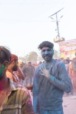 Barsana, Uttar Pradesh, Hindistan - 18 Mart 2024: Geleneksel giysiler ve rengarenk yüzlü Hindu erkek grubu, Barsana 'nın Rangili Gali' sindeki lathmar Holi 'yi geleneksel olarak kutluyorlar..