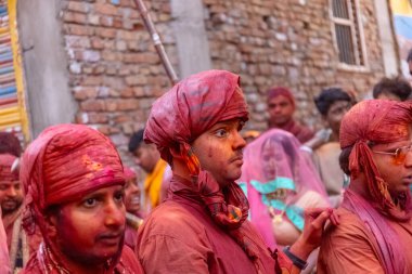 Barsana, Uttar Pradesh, Hindistan - 18 Mart 2024: Geleneksel giysiler ve rengarenk yüzlü Hindu erkek grubu, Barsana 'nın Rangili Gali' sindeki lathmar Holi 'yi geleneksel olarak kutluyorlar..