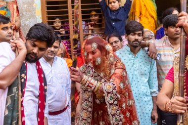 Barsana, Uttar Pradesh, Hindistan - 18 Mart 2024: Geleneksel giysiler ve rengarenk yüzlü Hindu erkek grubu, Barsana 'nın Rangili Gali' sindeki lathmar Holi 'yi geleneksel olarak kutluyorlar..