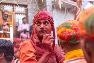 Barsana, Uttar Pradesh, Hindistan - 18 Mart 2024: Geleneksel giysiler ve rengarenk yüzlü Hindu erkek grubu, Barsana 'nın Rangili Gali' sindeki lathmar Holi 'yi geleneksel olarak kutluyorlar..
