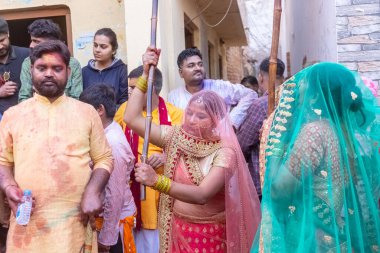 Barsana, Uttar Pradesh, Hindistan - 18 Mart 2024: Geleneksel giysiler ve rengarenk yüzlü Hindu erkek grubu, Barsana 'nın Rangili Gali' sindeki lathmar Holi 'yi geleneksel olarak kutluyorlar..