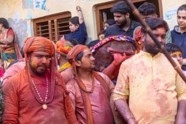 Barsana, Uttar Pradesh, Hindistan - 18 Mart 2024: Geleneksel giysiler ve rengarenk yüzlü Hindu erkek grubu, Barsana 'nın Rangili Gali' sindeki lathmar Holi 'yi geleneksel olarak kutluyorlar..