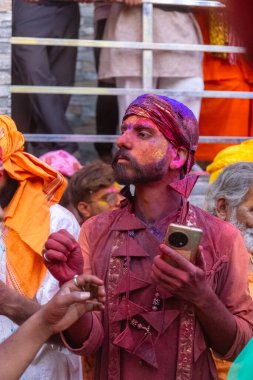 Barsana, Uttar Pradesh, Hindistan - 18 Mart 2024: Geleneksel giysiler ve rengarenk yüzlü Hindu erkek grubu, Barsana 'nın Rangili Gali' sindeki lathmar Holi 'yi geleneksel olarak kutluyorlar..