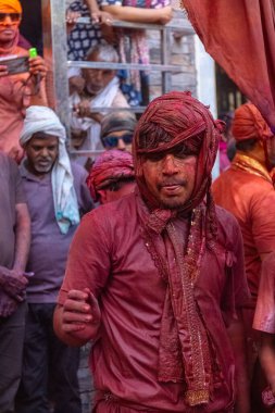Barsana, Uttar Pradesh, Hindistan - 18 Mart 2024: Geleneksel giysiler ve rengarenk yüzlü Hindu erkek grubu, Barsana 'nın Rangili Gali' sindeki lathmar Holi 'yi geleneksel olarak kutluyorlar..