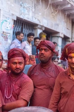 Barsana, Uttar Pradesh, Hindistan - 18 Mart 2024: Geleneksel giysiler ve rengarenk yüzlü Hindu erkek grubu, Barsana 'nın Rangili Gali' sindeki lathmar Holi 'yi geleneksel olarak kutluyorlar..